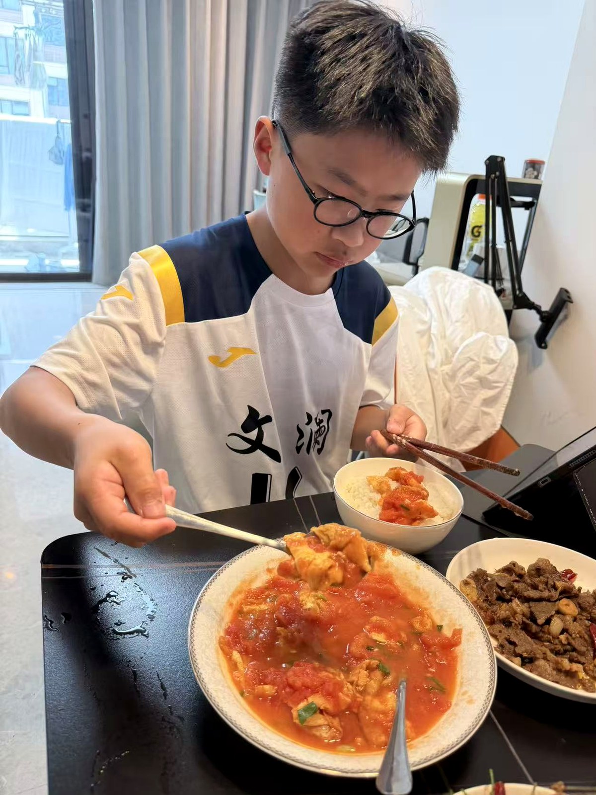 楼铮在餐桌前夹菜吃饭。